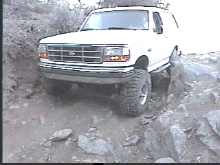 1993 Ford Bronco - This 1993 Ford Bronco is shown tackling a challenging off-road trail with large rocks.