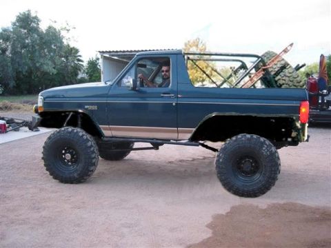 1980 Ford Bronco - A modified 1987 Ford Bronco with large off-road tires is parked outdoors.