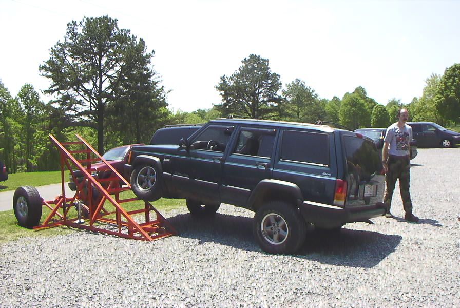 Jeep Cherokee XJ on a ramp with a man standing nearby