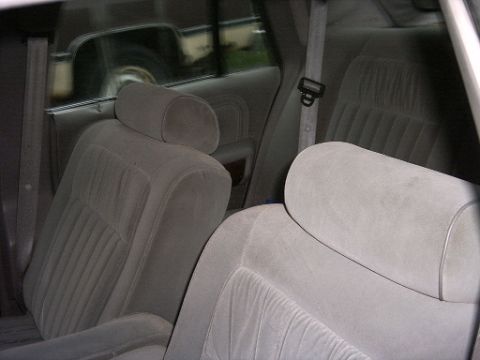 1990 Ford Crown Victoria LTD - The interior of a car, showing the rear seats and headrests with seatbelts.