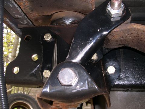 1994 Ford Bronco - Close-up view of black suspension components and hardware, with a tire visible in the lower left corner.
