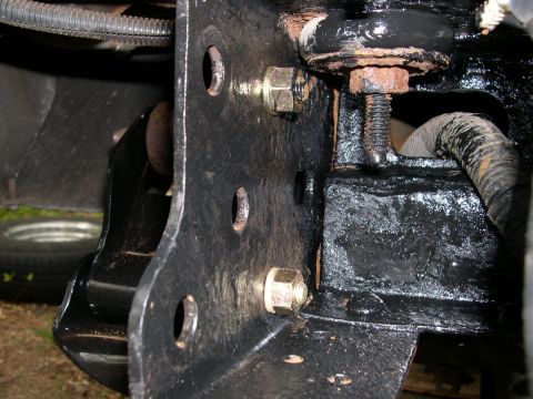1994 Ford Bronco - Detail shot of the vehicle's frame and suspension system, showing bolted components and a portion of a tire in the background.