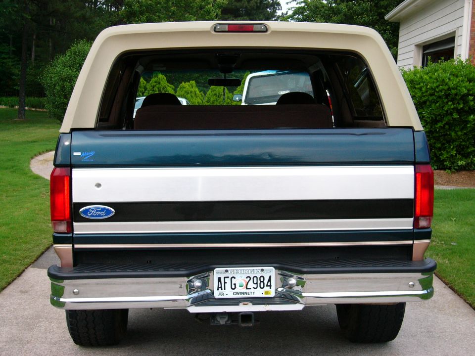 Rear of a green and tan Ford SUV with Georgia plate AFG-2984 and chrome bumper in a driveway