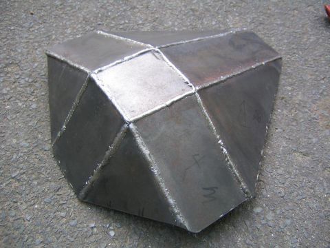 1978 Ford Bronco - This custom-fabricated metal skid plate features a unique, faceted design and is shown resting on a gravelly surface.