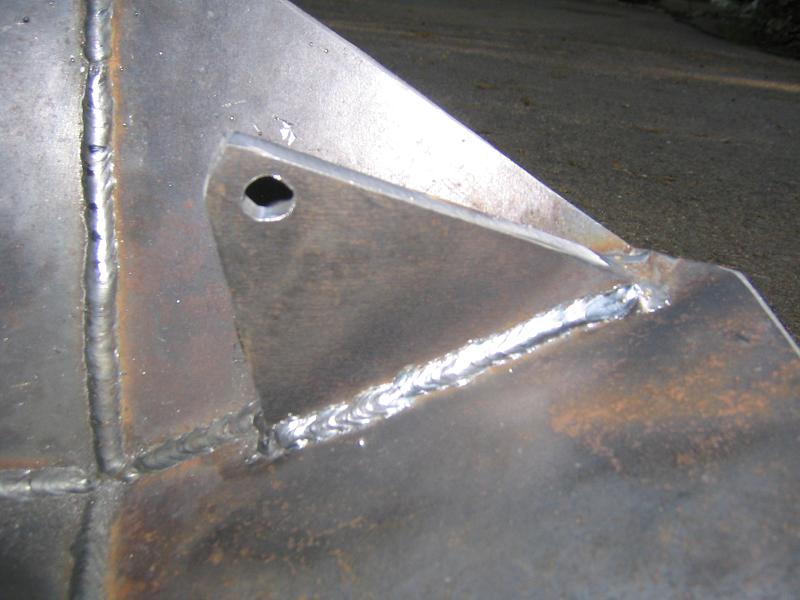 Welded metal part with a hole and visible weld seams