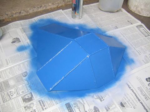 1978 Ford Bronco - A freshly spray-painted blue fabricated differential skid plate sitting on newspaper, its faceted welded steel panels still glossy with ove…