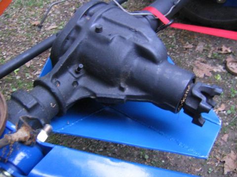 1978 Ford Bronco - A black-painted axle differential housing fitted with a blue welded steel skid plate wrapped under the pumpkin, photographed from above out…