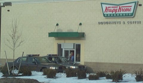 1991 Ford Crown Victoria LTD - Two police cars are parked outside a Krispy Kreme doughnut shop.