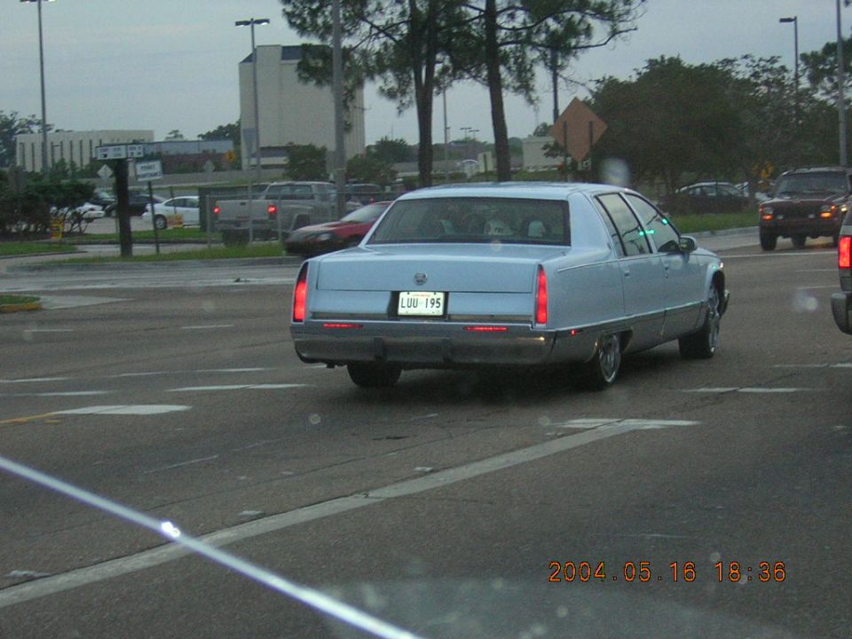 Light blue sedan with a license plate that reads LUU 195, driving on a street