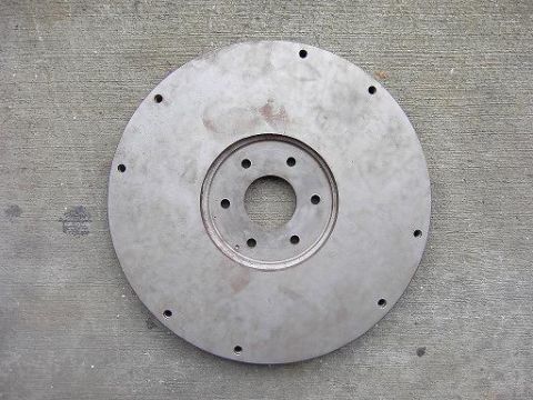 1980 Ford Bronco - A circular metal part, likely a flywheel, is shown against a concrete background.