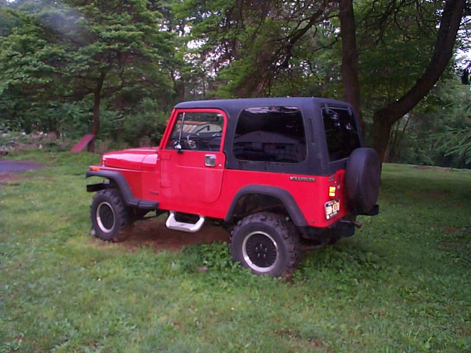 1989 Jeep YJ, red with black hardtop, parked in grassy area