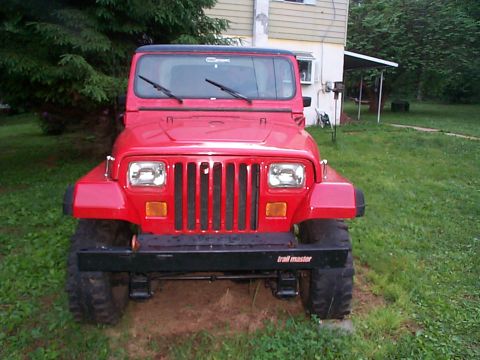 1989 Jeep YJ - Front view of a red 1989 Jeep YJ with a black hardtop and a Trail Master bumper.
