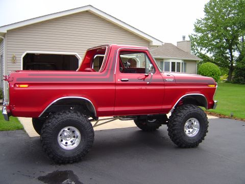 1978 Ford Bronco - This lifted 1978 Ford Bronco is parked in a driveway with a house and garage in the background.