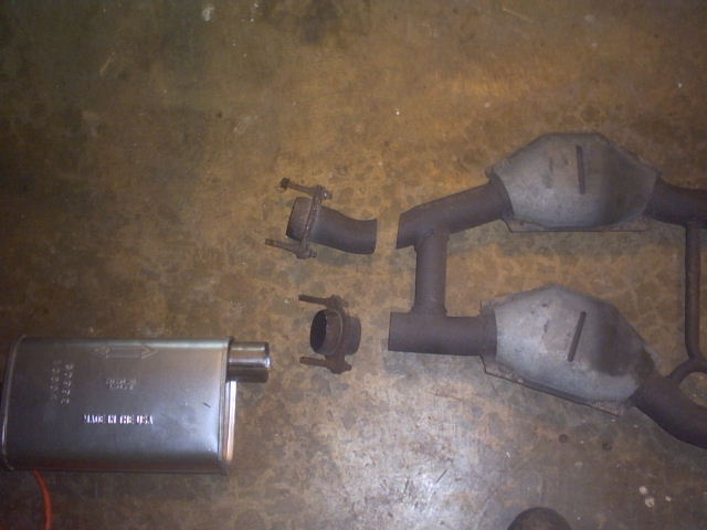 Exhaust muffler and catalytic converter pipes on a concrete floor