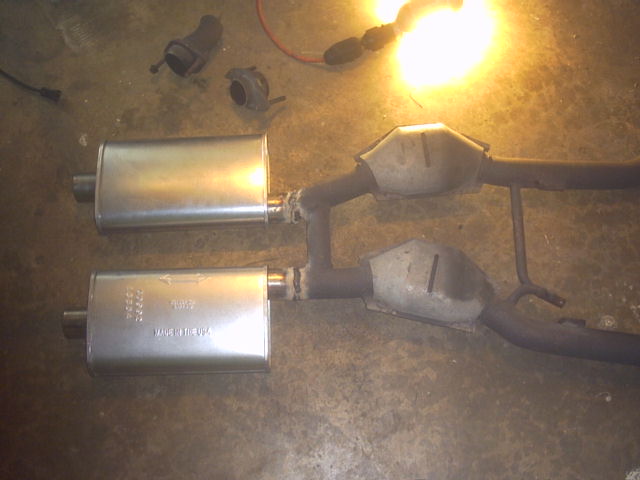 Exhaust system with two mufflers and two catalytic converters, parts scattered on the floor
