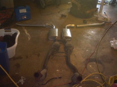 1991 Ford LTD Crown Victoria - The exhaust system, including mufflers and catalytic converters, is disassembled and placed on the floor.