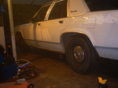 1991 Ford LTD Crown Victoria - This white 1991 Ford Crown Victoria sedan is viewed from the side, revealing its classic body style and chrome accents.