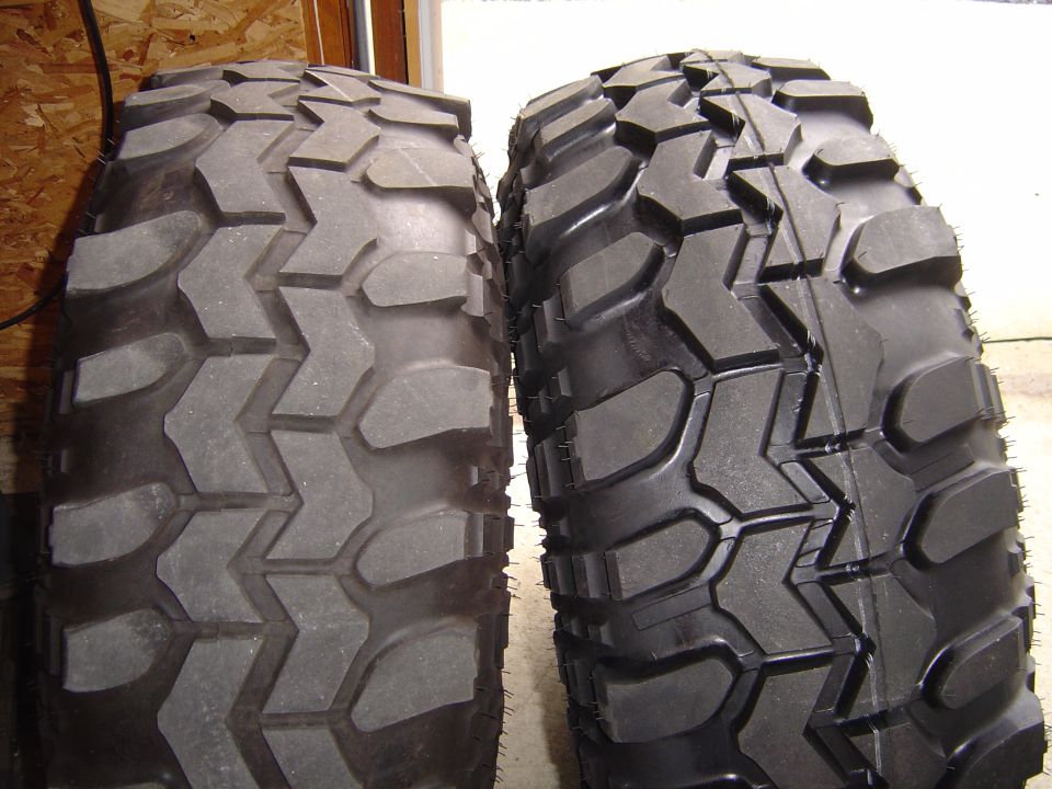 Two off-road tires side-by-side, one worn, one new