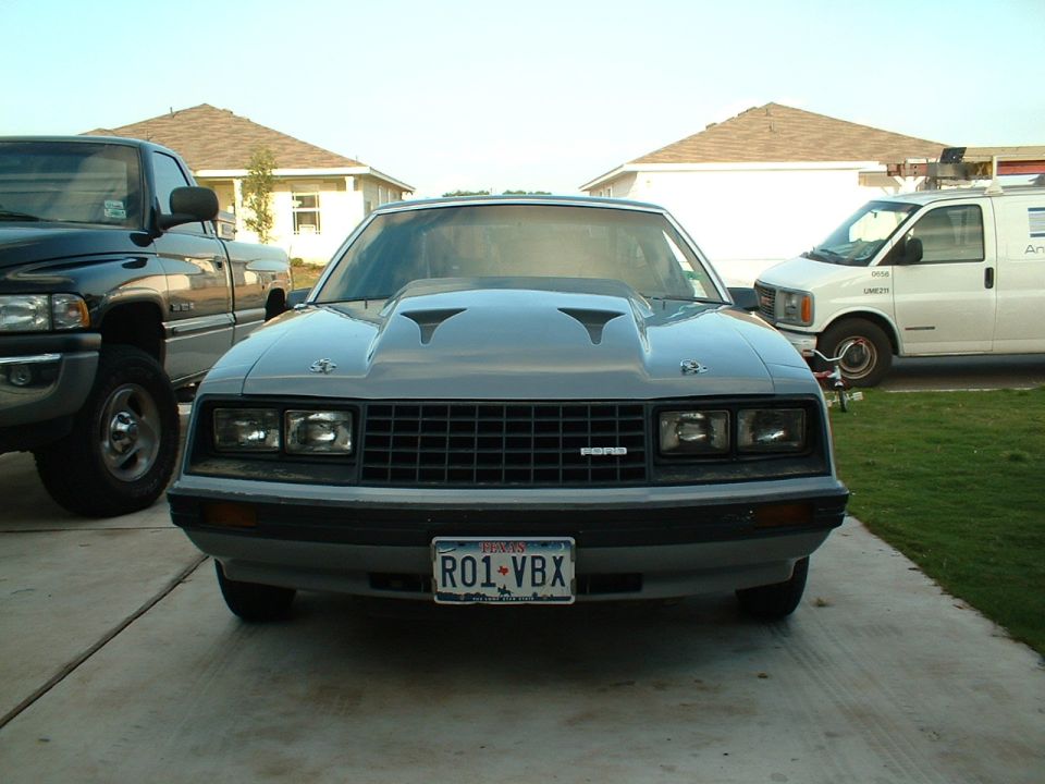 Gray 1979 Ford Mustang with a large hood scoop and aftermarket grille, front view