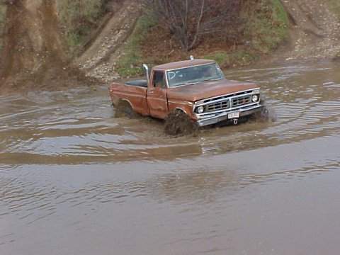 1976 Ford F-250 - This 1975 Ford F-250 navigates a muddy, water-filled terrain.
