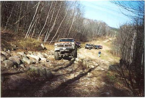 1976 Ford F-250 - A 1976 Ford F-250 navigates a challenging off-road course with several other vehicles in the background.