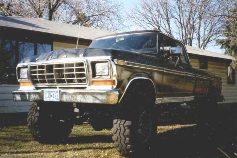 1978 Ford F-250 - This lifted 1978 Ford F-250 features a prominent chrome grille and bumper, with a dark paint job.