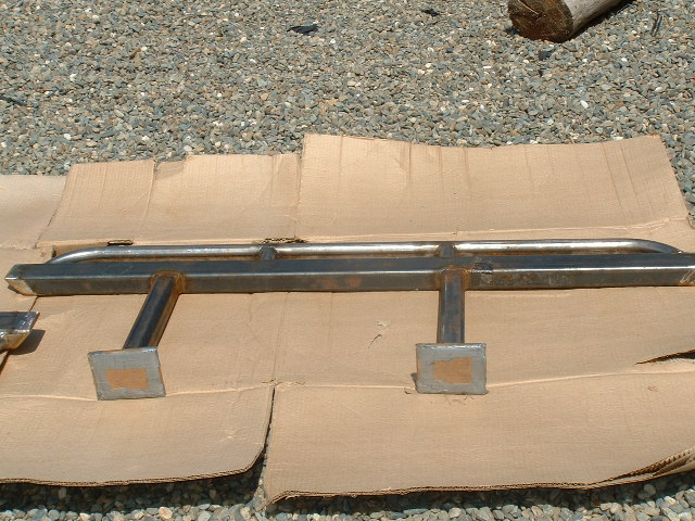 Metal slider bars with square mounting brackets, laid out on cardboard