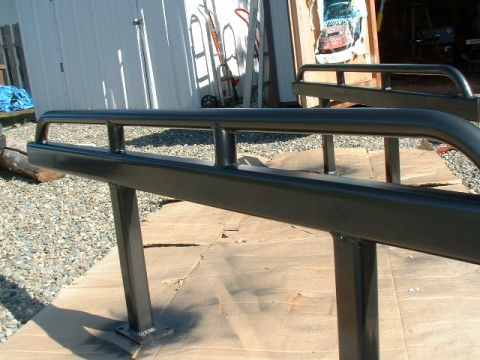 1991 Ford Bronco - Black metal sliders are shown on cardboard, with a Supermotors.net logo visible in the lower right corner.