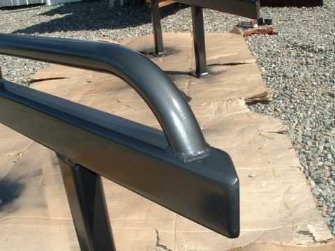 1991 Ford Bronco - Newly painted metal slider bars drying on cardboard.