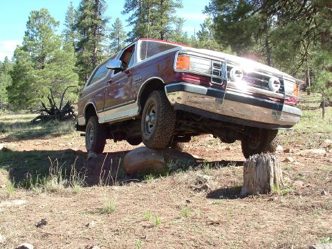 1990 Ford Bronco - This 1990 Ford Bronco is shown off-roading, demonstrating its capability on challenging terrain.