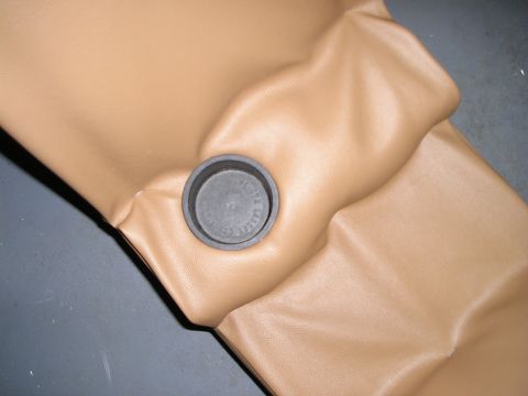 1996 Ford Bronco - Close-up of a tan center console with a black cap, likely an interior part.