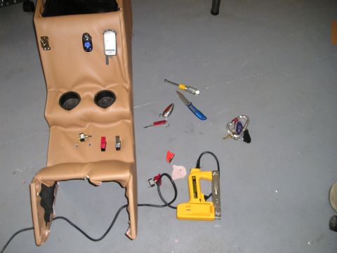 1996 Ford Bronco - A tan custom center console, likely for a vehicle, is shown with cup holders and various switches installed. Tools and fishing lures are sc…