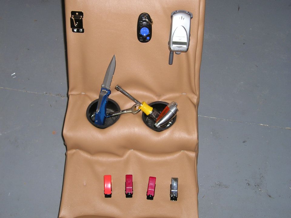 Pocketknife, lighters, phone and small items on tan padded surface