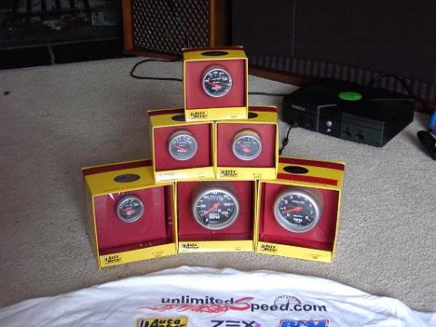 1980 Ford Bronco - Multiple Auto Meter gauges are displayed in their original packaging, with an Xbox console visible in the background.