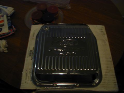 1988 Ford Bronco - A shiny Ford transmission pan is shown on a table, possibly for sale or repair.