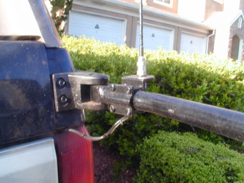 1988 Ford Bronco - Close-up of a vehicle's antenna mount and bracket assembly, with a pipe extending outwards.