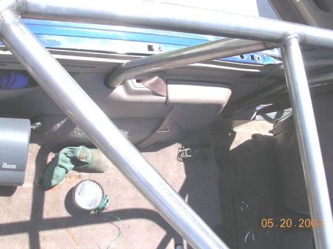 1994 Ford Bronco - The interior of a vehicle is visible, dominated by a metal roll cage structure.
