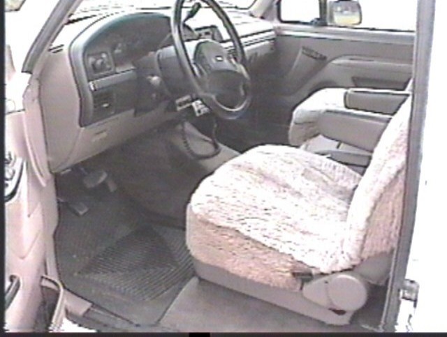 Gray interior of a Ford truck with steering wheel and fabric-covered seat