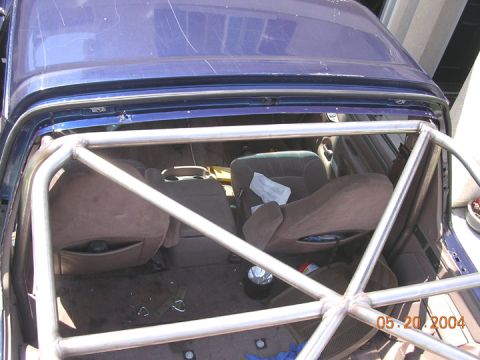 1994 Ford Bronco - The photo shows the interior of a blue SUV, focusing on the installed roll cage and rear seating area.
