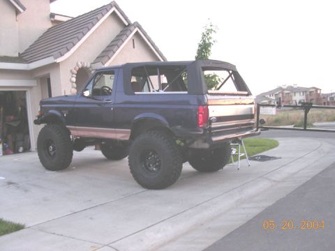 1994 Ford Bronco - Rear view of a lifted 1994 Ford Bronco with a soft top and aftermarket bumper.