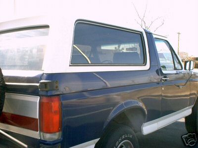 1987 Ford Bronco - This 1987 Ford Bronco is seen from a three-quarter front angle, highlighting its blue and white paint scheme.