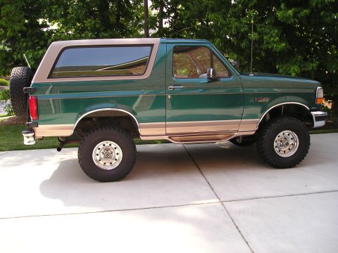 1996 Ford Bronco - This lifted 1996 Ford Bronco features a two-tone green and tan paint scheme and a spare tire mounted on the rear tailgate.