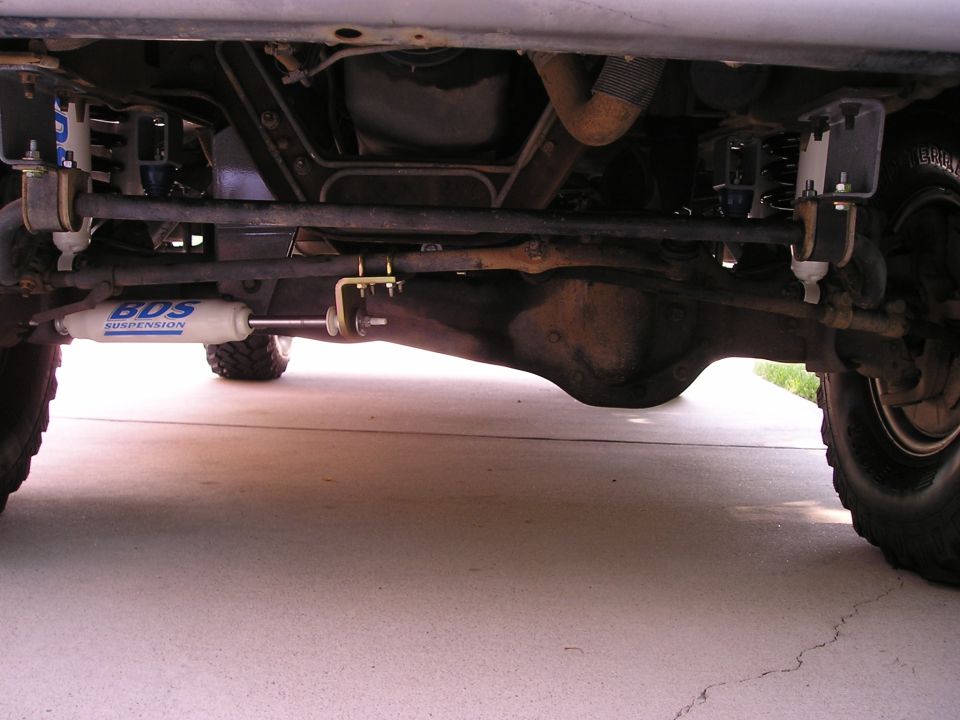 BDS steering stabilizer and shocks on a lifted solid front axle, viewed from below