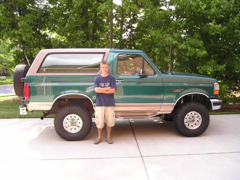 1996 Ford Bronco - A lifted green 1996 Ford Bronco is shown with a person standing in front of it.