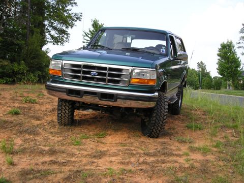 1996 Ford Bronco - Lifted 1996 Ford Bronco in a grassy, dirt area.