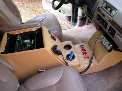 1996 Ford Bronco - Interior view of a 1996 Ford Bronco, highlighting a custom center console with added electronics and decorative items.