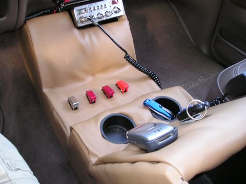 1996 Ford Bronco - Custom center console features a CB radio, several switches, and cup holders, with a knife and keys visible.