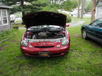 1997 Ford Taurus - Red 1997 Ford Taurus with hood open, parked in a grassy yard next to another vehicle.