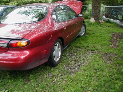1997 Ford Taurus - This 1996 Ford Taurus sedan is shown with its hood open, viewed from the rear quarter.