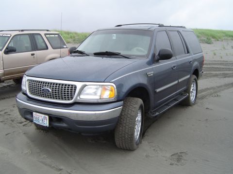 1989 Ford Bronco - Ford Expedition on a sandy beach with another SUV in the background.